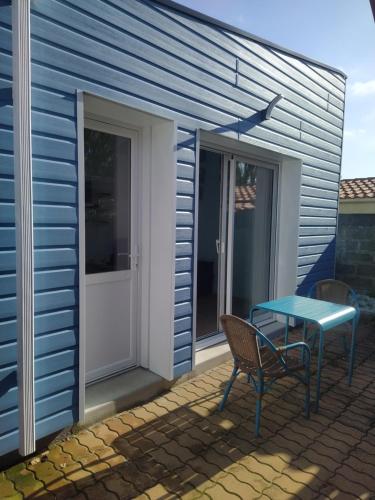 une table bleue et une chaise sur une terrasse dans l'établissement Le Palmier, à Les Sables-dʼOlonne