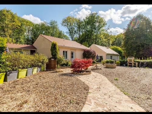 a house with a gravel driveway in front of a yard at Maison au bout du chemin in Gouvieux