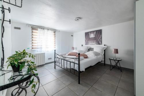 a bedroom with a bed and a plant and a window at Appartement Cosy - Proche Disneyland - Paris - RER in Noisy-le-Grand