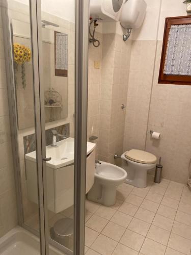 a bathroom with a toilet and a sink and a shower at La Casa al Mare di Giulia in Porto Potenza Picena