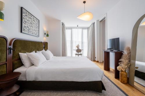 Un dormitorio con una gran cama blanca y un televisor. en Ando Living Taksim House, en Estambul