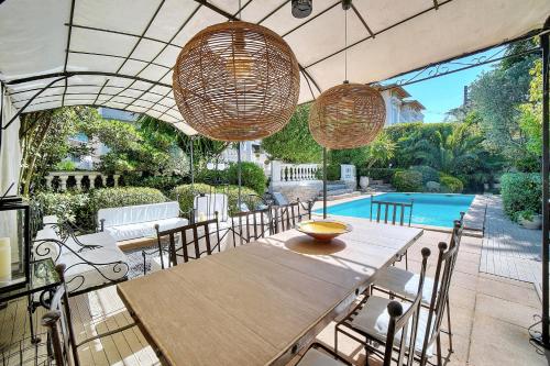 une salle à manger avec une table et des chaises et une piscine dans l'établissement REF 1821 - Cannes Near Center - Villa for rent, à Cannes