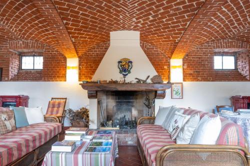 a living room with couches and a fireplace at Marchesi Incisa Winery Lodge in Rocchetta Tanaro