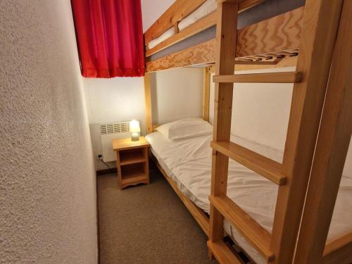 - une chambre avec 2 lits superposés et une table avec une lampe dans l'établissement Appartement 3 pièces, 4/6 pers, balcon, proche pistes à Valfréjus - FR-1-265-183, à Valfréjus