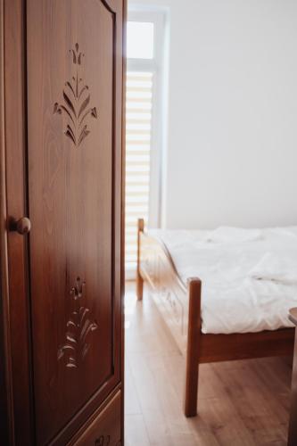 a bedroom with a bed and a wooden door at Zajazd Hetmański-Noclegi-Nowy Wiśnicz in Nowy Wiśnicz