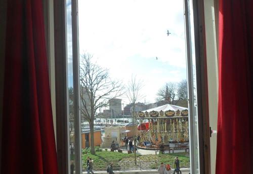 - une fenêtre avec vue sur un carnaval avec des personnes dans l'établissement L'Appart Du Vieux Port, à La Rochelle