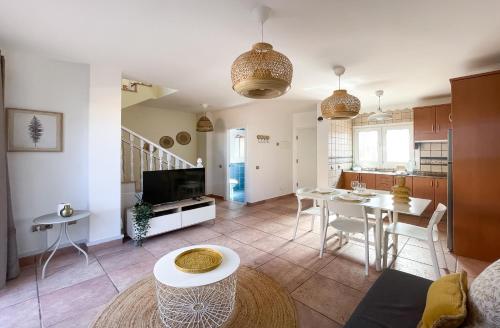 a living room with a table and a kitchen at Casa Dorada by Best Holidays Fuerteventura in Corralejo