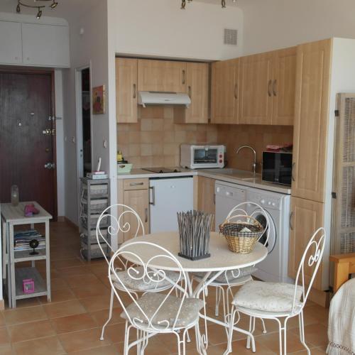 une cuisine avec une table et des chaises dans une pièce dans l'établissement Residence CORSE AZUR AJACCIO, à Ajaccio