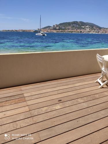 une terrasse avec vue sur l'océan et un bateau dans l'établissement Residence CORSE AZUR AJACCIO, à Ajaccio
