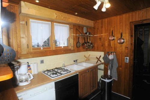 une cuisine avec un évier et une cuisinière four supérieur dans l'établissement Chalet d' Egloo 10-12 pers, à Samoëns
