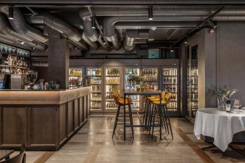a restaurant with a bar with yellow stools at Biologen Herdla in Askøy