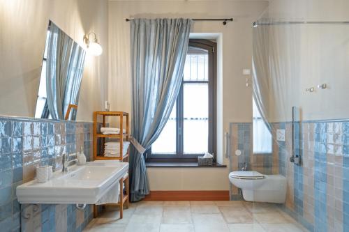 a bathroom with a sink and a toilet and a window at Marchesi Incisa Winery Lodge in Rocchetta Tanaro