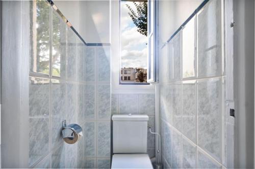 une salle de bain avec toilettes et fenêtre dans l'établissement Charming flat in old Paris, à Paris