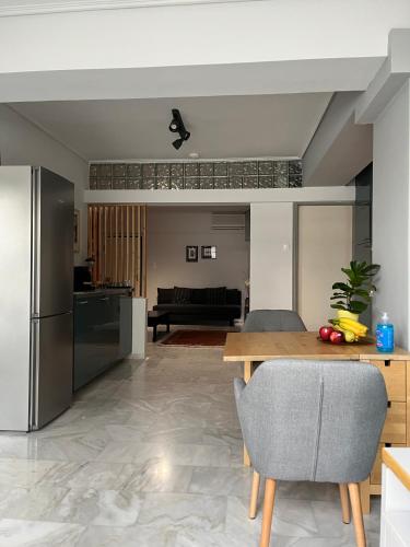 a kitchen and living room with a table and a refrigerator at Central loft D5 in Volos