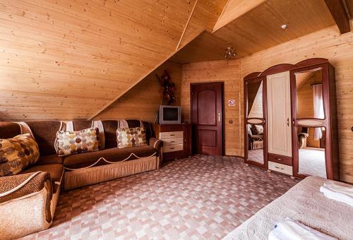 a living room with a couch in a wooden room at Готель Ольга in Tatariv