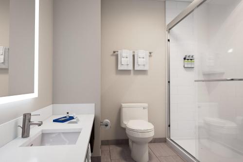a white bathroom with a toilet and a shower at Holiday Inn Express & Suites Cedar Rapids NE - Marion by IHG in Marion