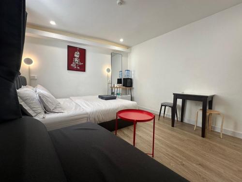 a small room with a bed and a table at The White Den Sukhumvit 44 in Bangkok