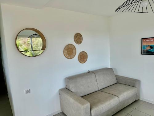 a living room with a couch and a mirror at Appartement Mare è Machja vue mer in Sari Solenzara