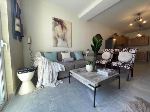 a living room with a couch and a coffee table at Deluxe Dream Villa in Għajnsielem