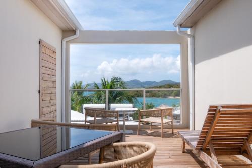 a balcony with a table and a view of the water at Hôtel Iloma in Sainte-Luce
