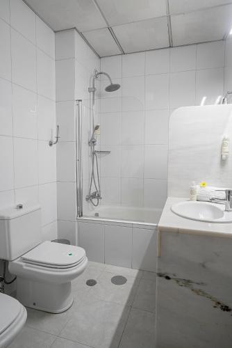a white bathroom with a toilet and a sink at Hotel Estacão - Braga in Braga