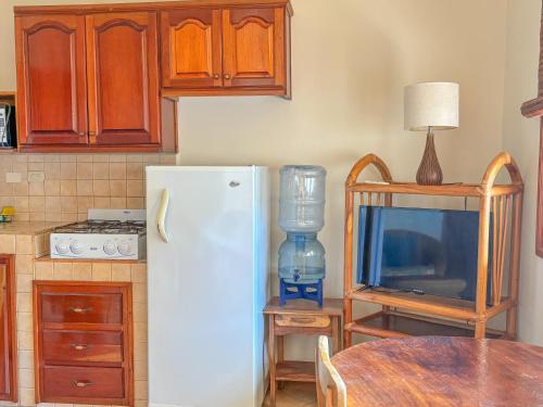 a kitchen with a white refrigerator and a table at Seville Suite in San Juan del Sur