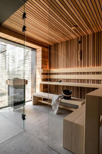 a bathroom with a glass shower and a bench at Villa T Apartments & SPA in Zakopane