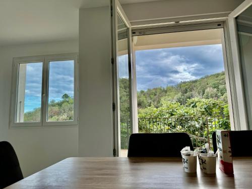 a room with a table and a large window at Villa Mare è Machja avec piscine et vue mer in Sari Solenzara