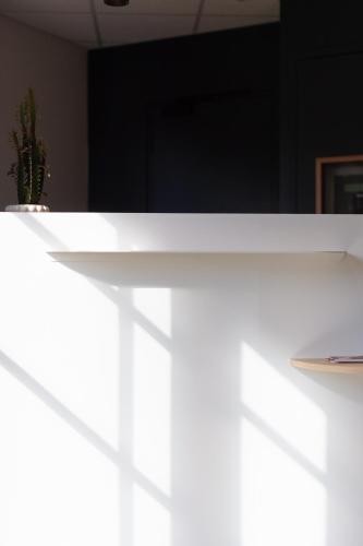 a white table with a plate and a plant on it at Appart Hotel Neostelia in Annecy