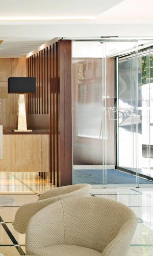 a living room with a couch and a large window at TURIM Saldanha Hotel in Lisbon