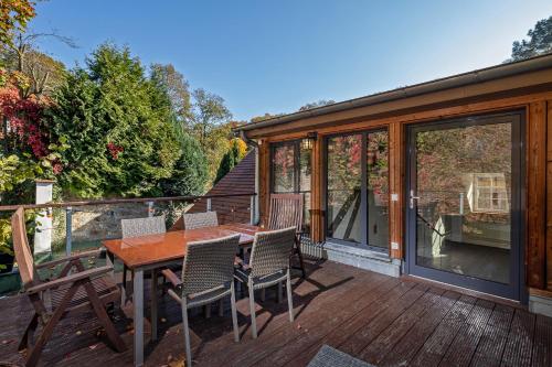 a deck with a wooden table and chairs on a house at Luxuriöse Sandstein Villa - 320 qm - 7 Räume in Dresden