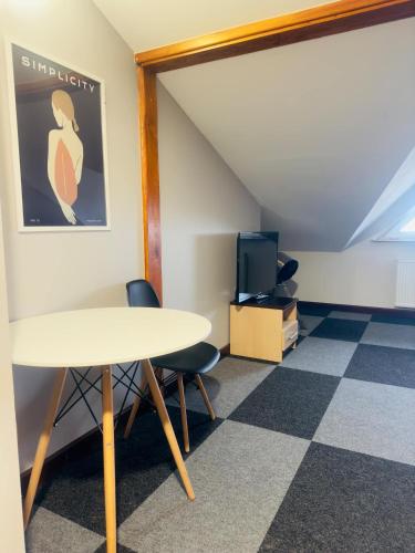 a room with a table and chairs and a tv at Magiczna Farma Hotel Obiady Mąka i Magia in Zambrów
