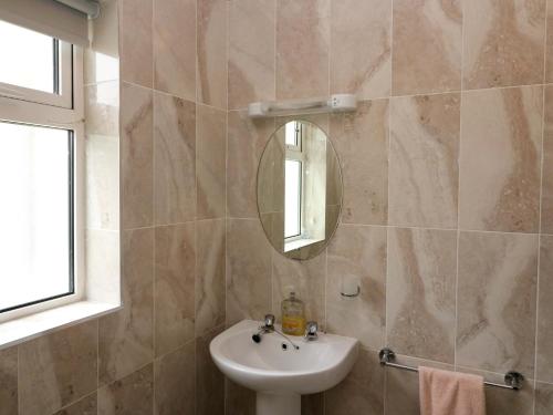 un baño con lavabo y espejo en No 1 Lodge Wood, en Kenmare