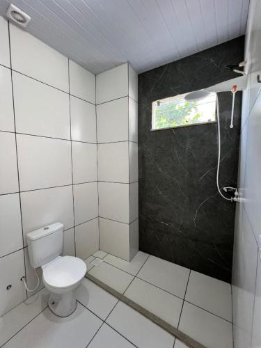a bathroom with a toilet and a window at ABA Hotel in Belém