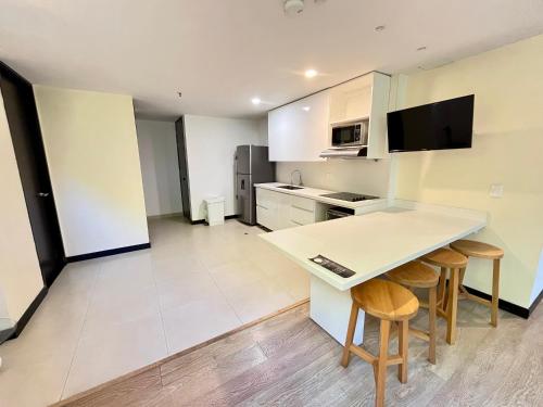 a kitchen with a table and stools in a room at Room in BB - Suite Presidencial en hotel proximo al aeropuerto in San Antonio de Pereira