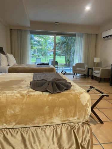 a hotel room with two beds and a large window at Cacao Suites With Pool in Coronado Luxury Club Golf & Beach in Chame