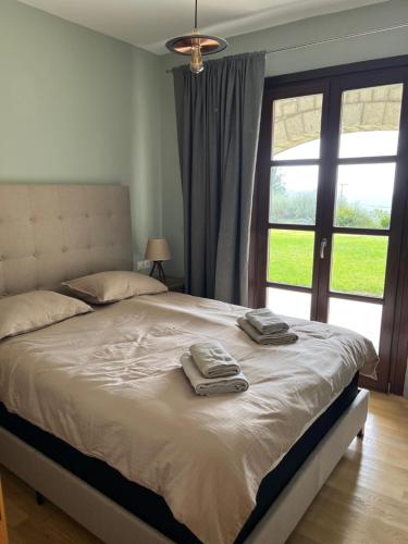 a bedroom with a bed with two towels on it at Delphi Gorge-view Chalet, Arachova in Arachova