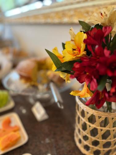 a vase filled with flowers sitting on a counter at Ville Del Bosco Hotel in São Marcos