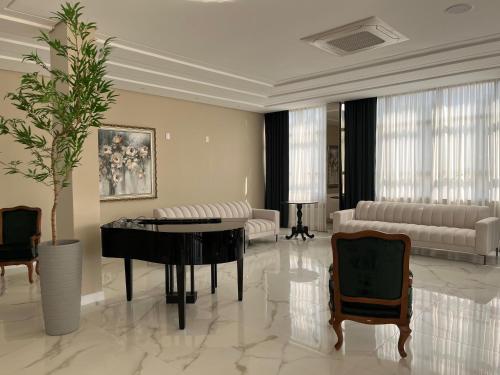 a living room with a piano and a couch at Ville Del Bosco Hotel in São Marcos