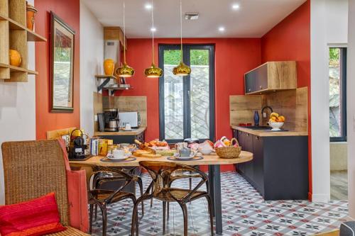 a kitchen with orange walls and a table and chairs at "Le 139" FRONT DE MER - Grand appartement contemporain 2 à 6 personnes - 1er étage in Houlgate