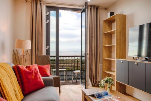 a living room with a couch and a view of the ocean at "Le 139" FRONT DE MER - Grand appartement contemporain 2 à 6 personnes - 1er étage in Houlgate