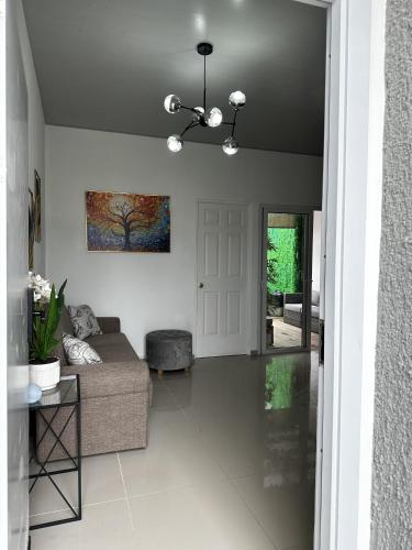 a living room with a couch and a painting on the wall at Casa Los Ausoles con Jacuzzi in Ahuachapán