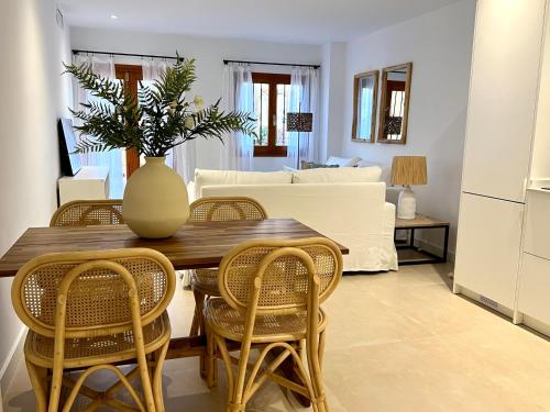einem Esstisch mit Stühlen und einer Vase darauf in der Unterkunft Beach LUXURY - ALTEA Puerto de Campomanes in Altea