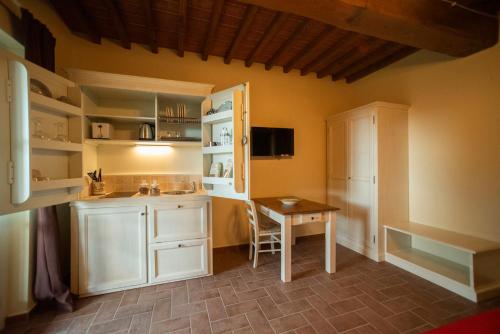 a small kitchen with a table and a refrigerator at Casale La Querce in Civitella in Val di Chiana