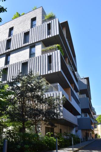 an apartment building with white balconies and a tree at SweetHomeVersailles 10mn walk from Palace in Versailles