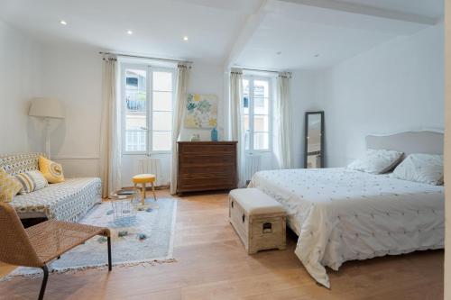 a white bedroom with a bed and a couch at Nid d amour en plein coeur des clochets in Le Beausset