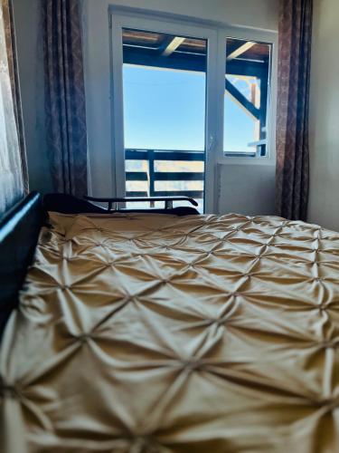 a bed in a bedroom with a large window at Cabana La Coco Horea in Arada