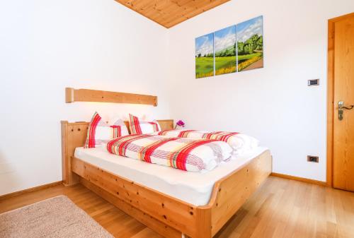 a bedroom with a bed with red and white pillows at Alps Residence in Nova Ponente