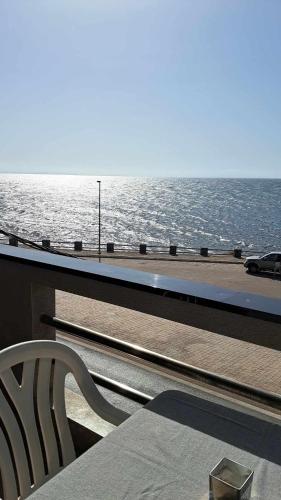 a bench sitting on a balcony looking at the ocean at Résidence touristique les jasmins الياسمين in Les Sablettes Mazagran-Plage