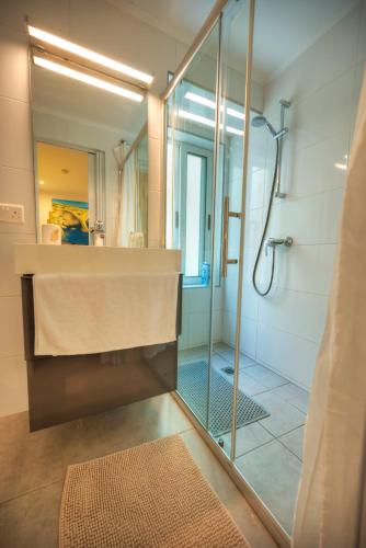 a bathroom with a shower and a sink and a mirror at Seaview Sliema 30 seconds to High Street & Ferry, 2x Double En-suite Bedrooms, Modern Whole Traditional Townhouse, Kitchen, Living Area, & Roof Terrace in Sliema